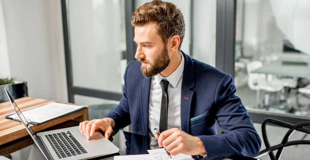 Dirigeant regardant un annuaire professionnel sur écran d'ordinateur